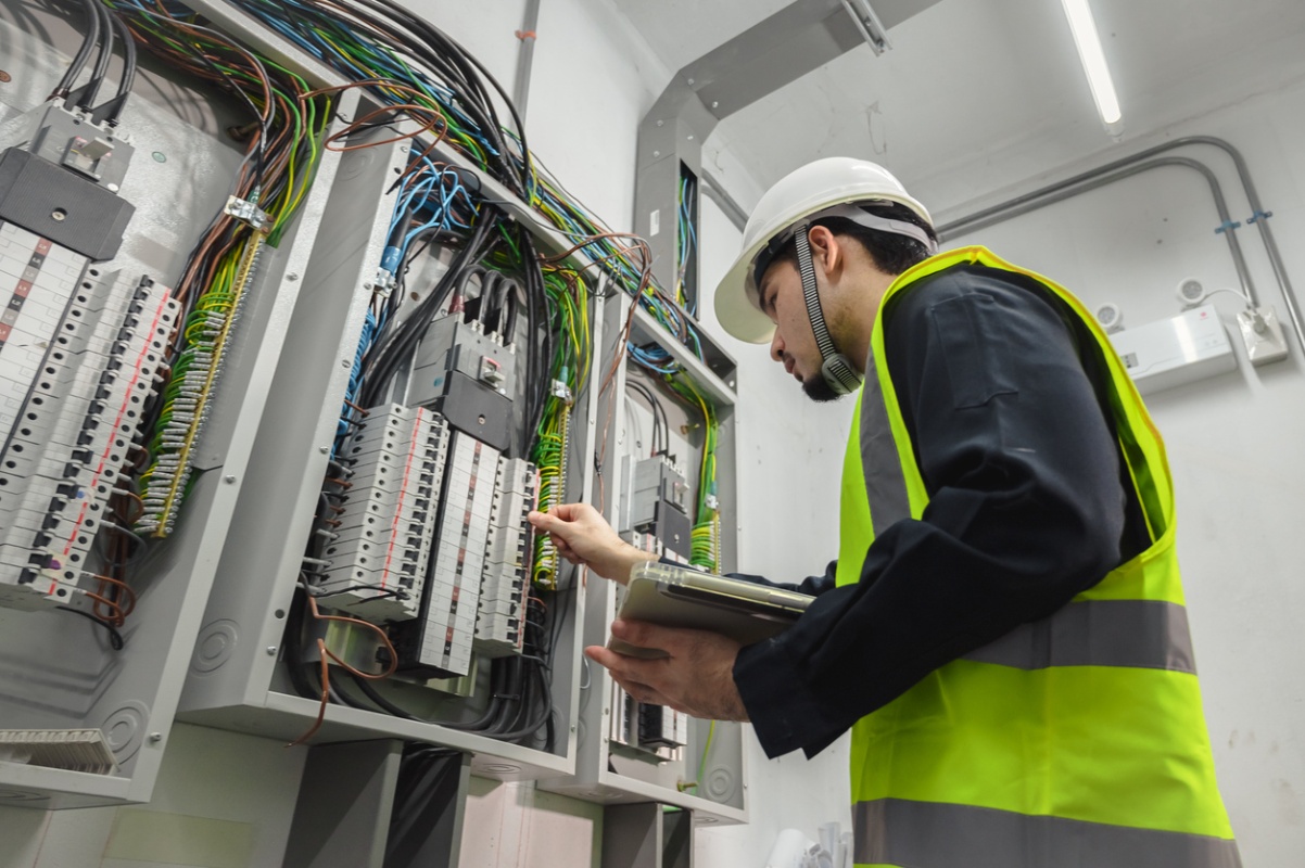 Elektriker ser inn i et strømskap